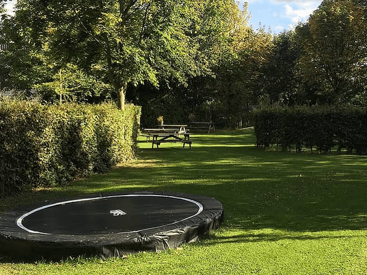 groepsaccommodatie-60-personen-8 Tuin met trampoline bij een van de huizen