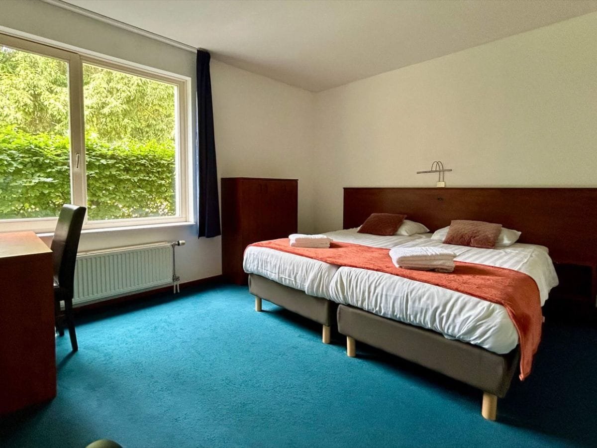 groepsaccommodatie-berg-en-dal-3 Comfortabele slaapkamers met opgemaakte bedden in de accommodaties